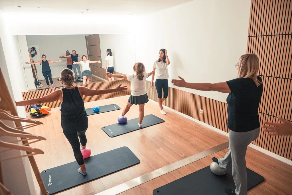 Aula de grupo no estúdio de pilates, com espelho e ripado de madeira