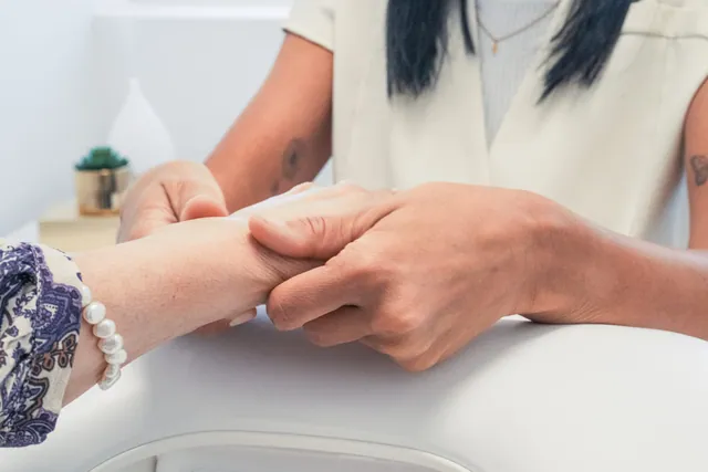 Profissional a segurar as mãos de uma cliente